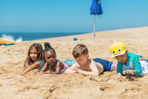 Ways to Socialize - Children Lying on Brown Beach Sand